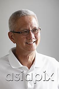 AsiaPix - head shot of mature man with grey hair looking away and smiling.