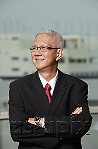 AsiaPix - mature man wearing a suit smiling with arms crossed