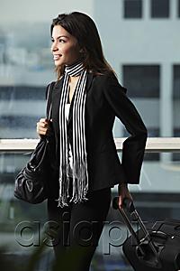 AsiaPix - Young woman holding bag and pulling suitcase