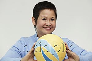 AsiaPix - Mature woman holding a volleyball and smiling