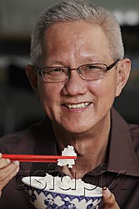 AsiaPix - head shot of mature man holding chopsticks and bowl of rice