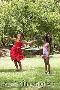 Asia Images Group - two little girls playing with hula hoop