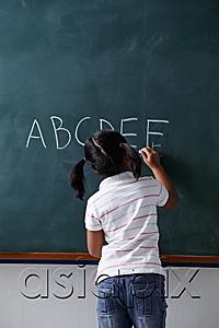 AsiaPix - rear view of young girl writing on chalk board