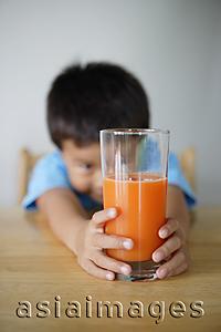 Asia Images Group - Little boy looking at glass of juice