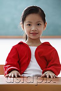AsiaPix - Portrait of young girl sitting at desk in classroom