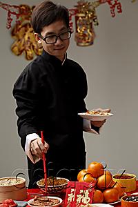 AsiaPix - Young man getting food at Chinese New Year party
