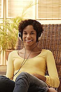 Mind Body Soul - Young woman listening to music and smiling.