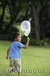 Asia Images Group - boy chasing butterflies with net
