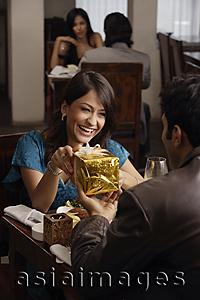 Asia Images Group - young man giving present to young woman