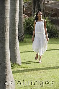 Asia Images Group - teen girl walking on grass in park