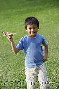 Asia Images Group - boy holding toy airplane