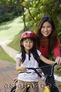 Asia Images Group - Mother teaching daughter to ride bicycle