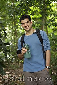 Asia Images Group - Man wearing a backpack, holding water bottle