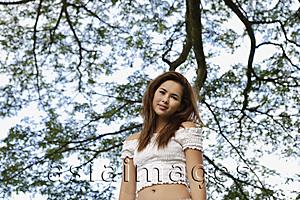 Asia Images Group - Young woman standing under tree