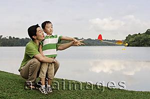 Asia Images Group - Father and son playing with toy airplane