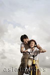 Asia Images Group - Father teaching son how to ride bike