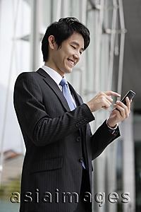 Asia Images Group - Businessman sending message on mobile device