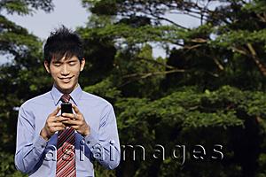 Asia Images Group - Young man reading text messages