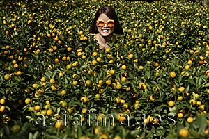 Asia Images Group - Young woman among orange plants