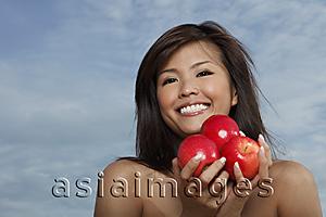 Asia Images Group - Young woman holding apples and smiling
