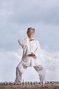 Asia Images Group - Older woman doing martial arts.