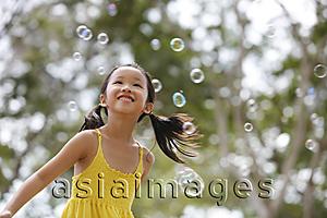 Asia Images Group - Young girl playing with bubbles.