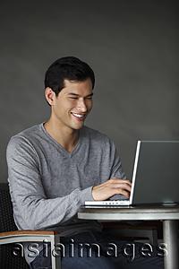 Asia Images Group - man working on laptop, smiling