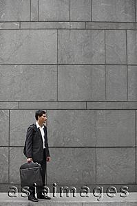 Asia Images Group - businessman holding briefcase and wearing backpack