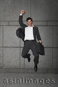 Asia Images Group - businessman holding briefcase, jumping with arm raised