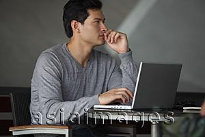 Asia Images Group - side profile of man working on laptop, thinking