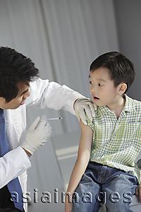 Asia Images Group - Doctor giving young boy an injection.