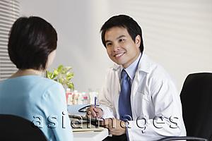 Asia Images Group - Doctor looking at patient in office