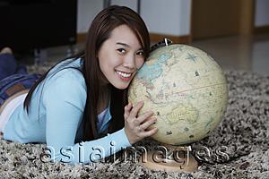 Asia Images Group - Young woman holding globe and smiling