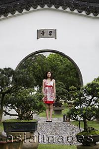 Asia Images Group - Young woman standing in Chinese garden