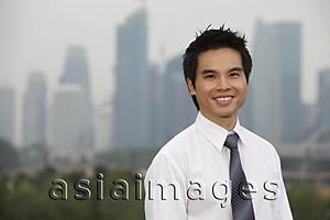 Asia Images Group - Chinese man standing in front of city skyline
