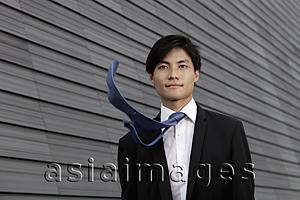 Asia Images Group - Chinese man wearing a suit with tie blowing in the wind