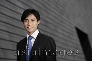 Asia Images Group - Chinese man wearing a suit smiling in front of building