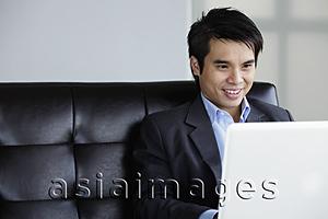Asia Images Group - Chinese man using laptop and smiling