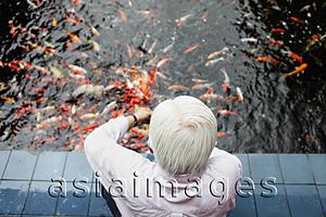 Asia Images Group - Top view of old man feeding Koi fish