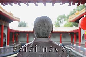 Asia Images Group - Old man with grey hair looking at Chinese Temple