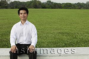Asia Images Group - Man in white shirt sitting on grass with eyes close