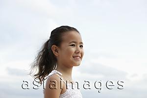 Asia Images Group - head shot of young girl smiling with clouds in background