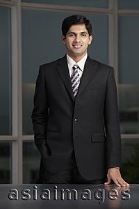 Asia Images Group - young man smiling and standing at desk