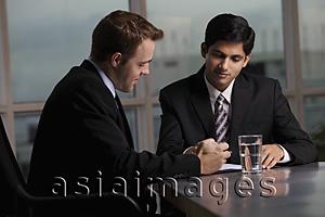 Asia Images Group - Indian man and Caucasian men discussing a document