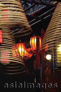 Asia Images Group - Red lanterns with incense coils in foreground