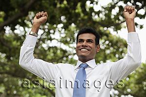 Asia Images Group - Indian man with his arms raised smiling outdoors