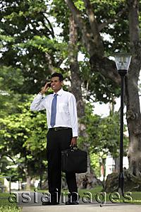 Asia Images Group - Indian man standing outside talking on phone
