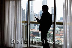 Asia Images Group - Profile of businessman near window with city as background