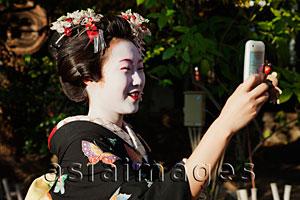 Asia Images Group - Japanese woman in traditional clothes taking a photo