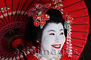 Asia Images Group - Japanese woman in traditional clothes, smiling and holding red umbrella